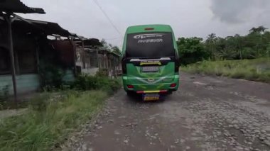 Asfalt yol araçların geçtiği deliklerle dolu, bazıları kuru, bazıları su altında.