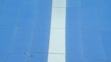 Yüzme havuzunda mavi beyaz seramik ile koşan bekar bir adam.