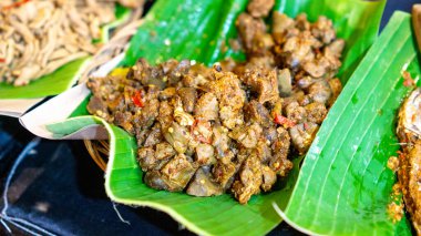 Hindistan cevizi yaprağından yapılmış tabağın içi muz yapraklarıyla kaplı..