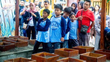Çocuklar kaplumbağa koruma üzerine çalışıyorlar. Kuma yerleştirilmiş yumurtalar için kutu..