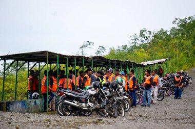Motosikletli taksi şoförleri istasyonda toplanıp müşterilerin hizmetlerini kullanmasını bekliyorlar..
