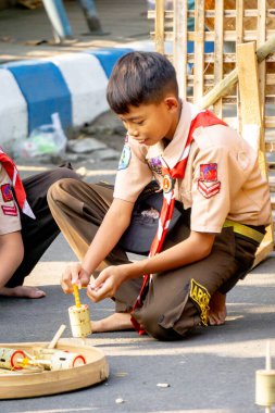 Endonezyalı insanlar parkta bambu ve ahşaptan yapılmış dönen top (torbalama, çete, gaz) oynuyorlar.