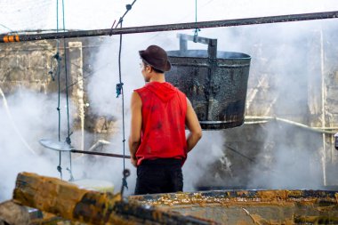 Esmer şeker yapma süreci. Esmer şeker, şeker kamışından yapılır..