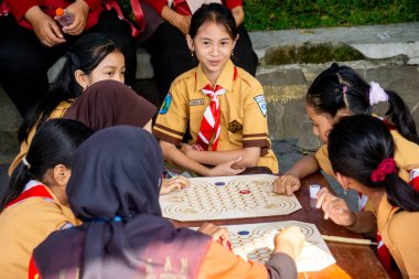 İlkokul izci üniformalı çocuklar geleneksel Endonezya oyunları oynuyor, görünüşe göre eğleniyorlar ve eğleniyorlar..