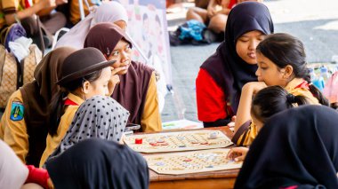 İlkokul izci üniformalı çocuklar geleneksel Endonezya oyunları oynuyor, görünüşe göre eğleniyorlar ve eğleniyorlar..