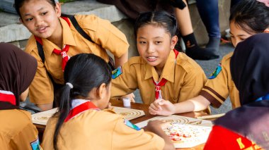 İlkokul izci üniformalı çocuklar geleneksel Endonezya oyunları oynuyor, görünüşe göre eğleniyorlar ve eğleniyorlar..