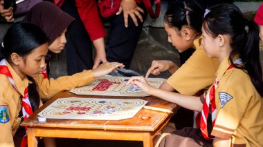 İlkokul izci üniformalı çocuklar geleneksel Endonezya oyunları oynuyor, görünüşe göre eğleniyorlar ve eğleniyorlar..