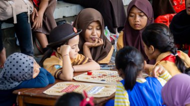 İlkokul izci üniformalı çocuklar geleneksel Endonezya oyunları oynuyor, görünüşe göre eğleniyorlar ve eğleniyorlar..