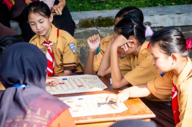 İlkokul izci üniformalı çocuklar geleneksel Endonezya oyunları oynuyor, görünüşe göre eğleniyorlar ve eğleniyorlar..