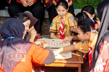 İlkokul izci üniformalı çocuklar geleneksel Endonezya oyunları oynuyor, görünüşe göre eğleniyorlar ve eğleniyorlar..