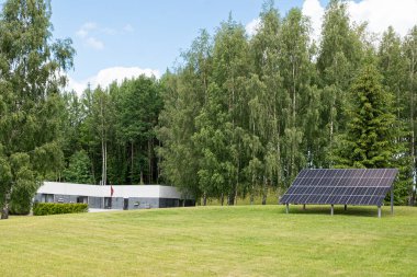 Yumuşak, tüylü bulutlarla dolu geniş bir gökyüzünün altında bakımlı ağaçlar ve yemyeşil çimlerle güzel korunan bir arazi. Huzurlu manzara huzur ve sükunet yayar, doğanın güzelliğini mükemmel bir uyum içinde gösterir..