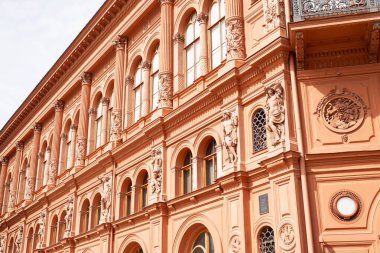 Eski Riga 'nın kalbindeki tarihi bina dekoratif mimari öğeler sergiliyor. Ön cephede, ortaçağ ve Art Nouveau stillerinin tipik dekoratif ayrıntıları, Letonya başkentinin cazibesini ve zengin kültürel mirasını yansıtıyor.