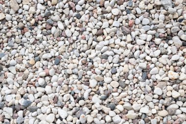 Küçük gri çakıl taşlarının pürüzsüz deseni doğal dokulu bir arka plan oluşturuyor. Peyzaj, tasarım materyalleri veya doğa temalı projelerde kullanım için ideal.