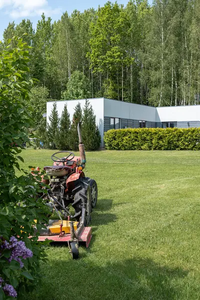 Arka planda modern tarzda bir konutu olan geleneksel bir kır çiftliğinin yer aldığı bir yaz manzarası. Mülkü çevreleyen yeşil çayır yeni ve huzurlu bir hava katıyor..