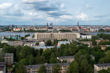 Riga Dönme dolabından çekilen renkli fotoğraf şehrin panoramik manzarasını gösteriyor. Görüntü, kilise kuleleri ve aydınlıkta parlayan Daugava Nehri ile tarihi Eski Şehir 'i gösteriyor..
