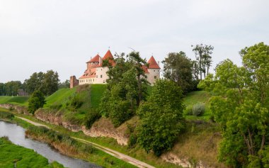 Letonya 'daki zarif Bauska Şatosu, tarihi bir ortaçağ kalesi ve kültürel mirası manzarayla çevrili..