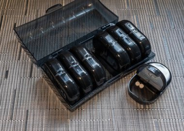 A weekly pill organizer with seven small compartments for each day of the week. Each compartment is divided into two sections for morning and evening doses, helping to manage daily medication efficiently.