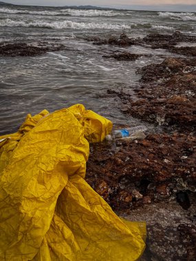 Plaj plastik atıkla kirlenmiş. Plastik şişeler sahilde. Çevre kirliliği.
