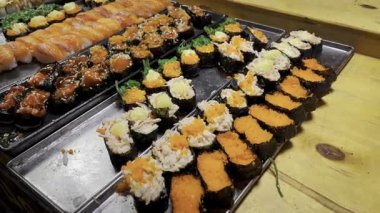 Nigiri çeşit çeşit rulo yapıyor. Türlü rulo. Sokak yemekleri Japon mutfağını sulandırıyor. Suşi, Rolls, Onigiri