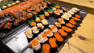 Nigiri çeşit çeşit rulo yapıyor. Türlü rulo. Sokak yemekleri Japon mutfağını sulandırıyor. Suşi, Rolls, Onigiri
