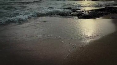 Deniz dalgaları kayalık kıyıya çarpar ve beyaz köpük oluşturur. Dalgalar kayalık kıyılarda