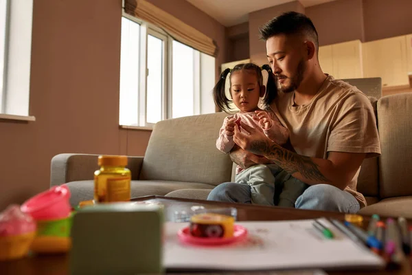 Father Giving Multivitamin Jelly Daughter His Arms Sofa Home Asian — Foto de Stock