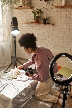 Armut, altın toplar ve çiçeklerle fotoğraf çektiği için mum bağlayan siyah kadın fotoğrafçı. Fotostoklar, ticaret, sosyal ağlar ve reklamlar için güzellik ve vücut bakımı içeriği