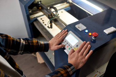 Fabrikadaki CNC makinesinin kontrol panelinde kısmi erkek işçi ya da mühendis düğmesi var. Modern teknoloji endüstriyel üretim kavramı. Otomatik akıllı makine ekipmanı