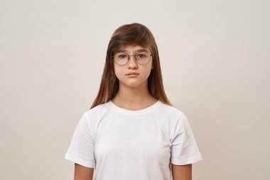 Kameraya bakan Kafkas ergen bir kızın ön görüntüsü. Zoomer kuşağının dişi çocuğu gözlük takıyor. Modern genç yaşam tarzı. Beyaz arka planda izole edilmiş. Stüdyo çekimi. Boşluğu kopyala