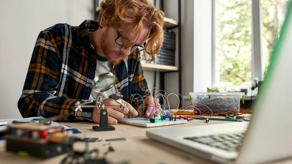 Elektronik Ekipmanlardaki Kablo Kabloları Işığa Bağlayan Erkek Bilişim Mühendisi Masada — Stok fotoğraf