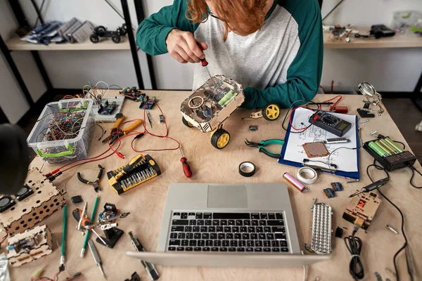 Young Male Technician Fixing Broken Wheel Robot Screwdriver Table Laptop — Stock Photo, Image