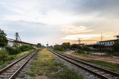 Tayland kırsalında gün batımlı tren rayları