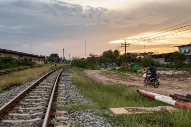 Tayland kırsalında gün batımlı tren rayları