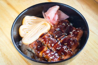 Japon pilavlı ızgara yılan balığı zencefilli turşu ve tatlı yumurta içerir. Donburi menüsü.