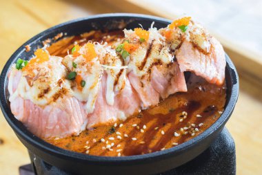 Izgara somon suşisi kremalı salata ve baharatlı sos Japon ızgarasına konur, suşi Japon halkı için geleneksel ve popüler bir yemektir..