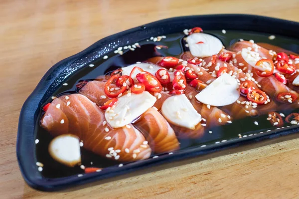 Soy sauce pickled salmon inblack plate. Japanese food.
