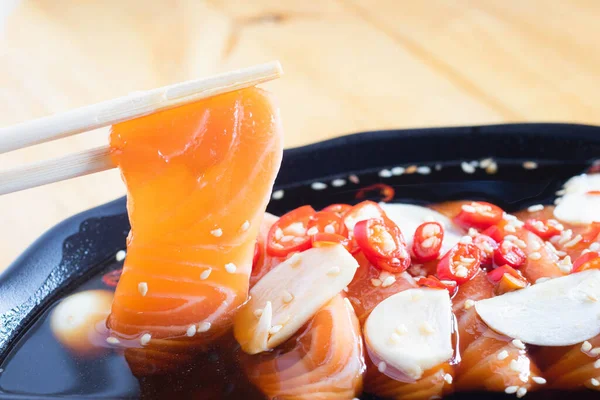 Soy sauce pickled salmon inblack plate. Japanese food.
