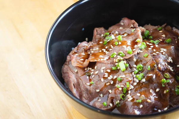 Stock image Wagyu beef Donburi with Japanese rice in black bowl.