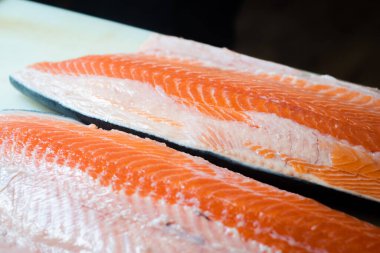 Somon filetoları büyük bir kesme tahtasına yerleştirilir, somonların tazeliğini gösterir.