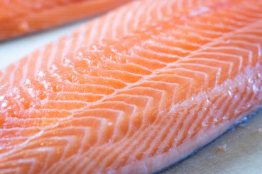 Somon filetoları büyük bir kesme tahtasına yerleştirilir, somonların tazeliğini gösterir.