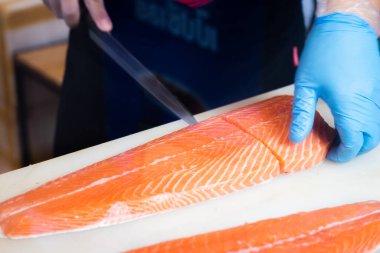 Japon aşçılar somon filetosu fileto yapıyor, filetoyu en iyi şekilde yapmak için hassas bir profesyonel beceri..