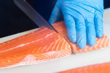 Japon aşçılar somon filetosu fileto yapıyor, filetoyu en iyi şekilde yapmak için hassas bir profesyonel beceri..