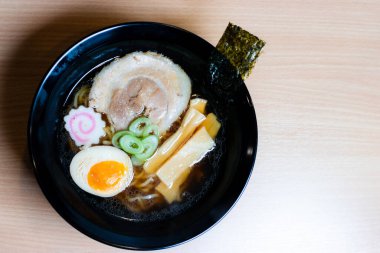 Siyah bardakta soya soslu ramen sosu, üzerine chashu domuz eti, Naruto balık köftesi, soya soslu yumurta turşusu, menma bambu filizleri ve yosun. Ramen kendine özgü bir Japon usulü şehriye çorbası..