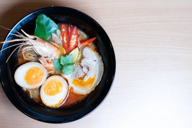 Tom Yum Ramen üzerine chashu domuz eti, soya soslu yumurta turşusu, nehir karidesi ve Tom yum baharatları. Tom Yum Ramen, Taylandlı Tom Yum ile birleşerek lezzetli bir tat veren Japon usulü bir eriştedir..