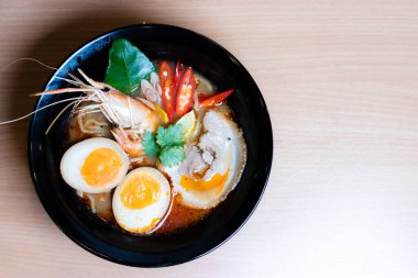 Tom Yum Ramen üzerine chashu domuz eti, soya soslu yumurta turşusu, nehir karidesi ve Tom yum baharatları. Tom Yum Ramen, Taylandlı Tom Yum ile birleşerek lezzetli bir tat veren Japon usulü bir eriştedir..