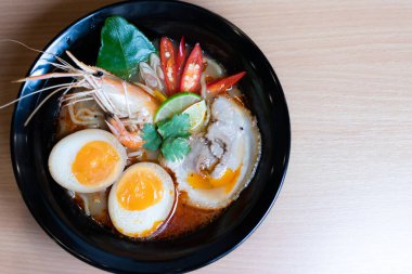 Tom Yum Ramen üzerine chashu domuz eti, soya soslu yumurta turşusu, nehir karidesi ve Tom yum baharatları. Tom Yum Ramen, Taylandlı Tom Yum ile birleşerek lezzetli bir tat veren Japon usulü bir eriştedir..