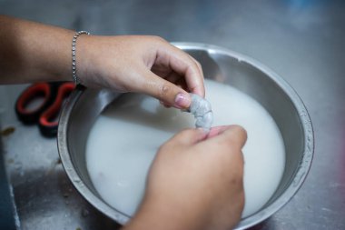 Karidesleri soyan eller, karides kokusunu azaltmak için una batırır..