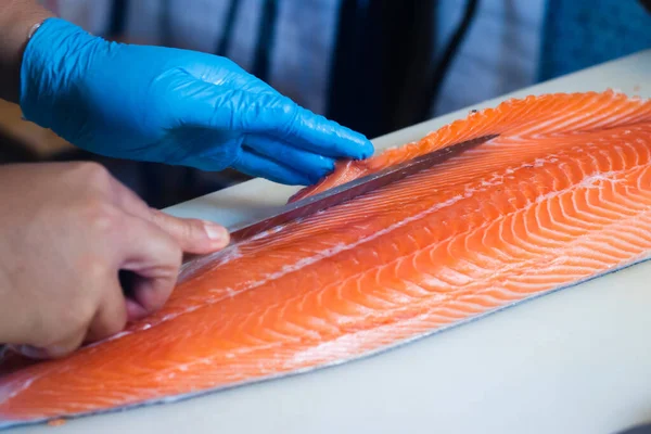 Japon aşçılar somon filetosu fileto yapıyor, filetoyu en iyi şekilde yapmak için hassas bir profesyonel beceri..