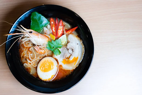 Tom Yum Ramen üzerine chashu domuz eti, soya soslu yumurta turşusu, nehir karidesi ve Tom yum baharatları. Tom Yum Ramen, Taylandlı Tom Yum ile birleşerek lezzetli bir tat veren Japon usulü bir eriştedir..