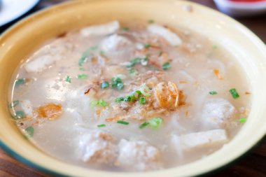Vietnamese Noodles Including Vietnamese sausage and minced pork topped with spring onions and fried onions in a bowl